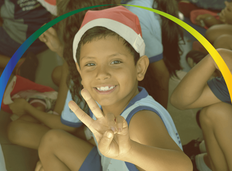 Criança sorrindo e olhando para a câmera