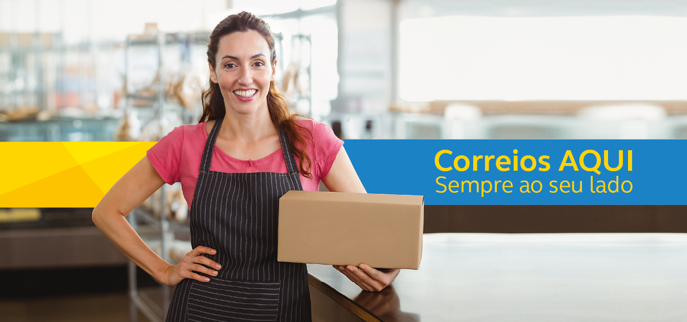 Moça sorridente branca e cabelo castanho claro semi preso com camiseta rosa e avental marrom escuro, com a mão na cintura e uma caixa de encomenda na outra mão. Faixa amarela e azul com a frase: Correios aqui. Sempre ao seu lado.