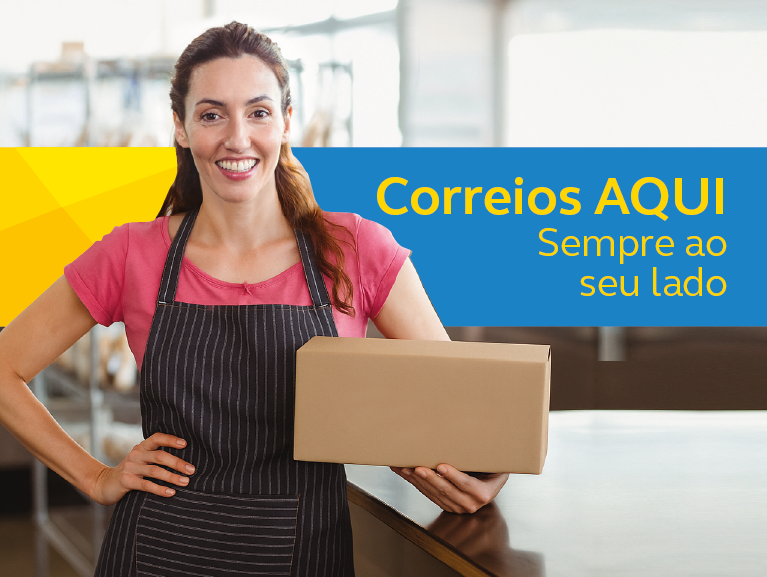 Moça sorridente branca e cabelo castanho claro semi preso com camiseta rosa e avental marrom escuro, com a mão na cintura e uma caixa de encomenda na outra mão. Faixa amarela e azul com a frase: Correios aqui. Sempre ao seu lado.