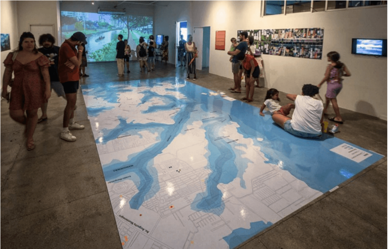 A foto apresenta uma fotografia que lembra várias pessoas que visitando um museu.