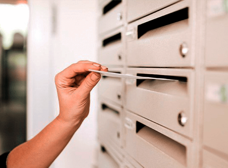 mão colocando uma carta na caixa de correios