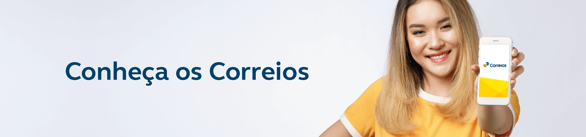 Imagem de uma moça oriental sorridente com os cabelos loiros nos ombros e camiseta amarela mostrando o celular com a tela para frente em primeiro plano e a marca dos Correios. Ao lado esquerdo dela a frase: Conheça os Correios.